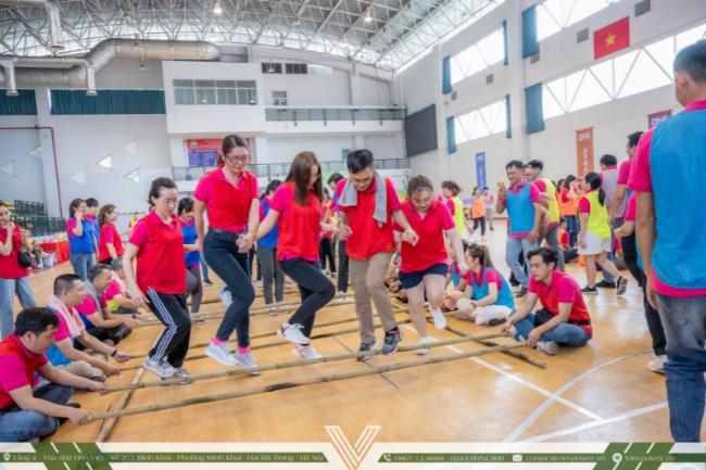 Một nhóm thanh niên vui vẻ tương tác và cười đùa trong khi chơi trò chơi vận động ngoài trời